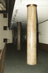 860264 Gezicht op enkele natuurstenen zuilen in een gang op een verdieping in het leegstaande hoofdkantoor van de ...